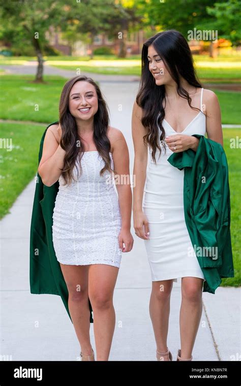 two college girls and best friends walk on a sidewalk while holding