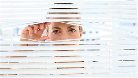 businessman spying through blinds and getting caught by camera in the office stock footage video