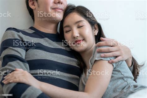 Cheerful Smiling Asian Couple In Love Hugging In The Bedroom Stock