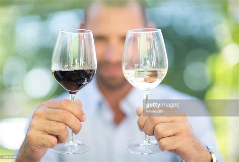 man comparing white wine and red wine on a wine tasting session photo