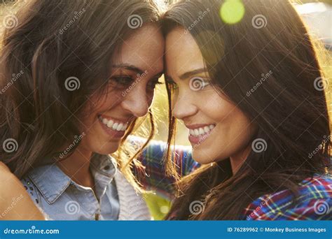 Lesbian Couple Embrace Outdoors Look To Each Other Close Up Stock