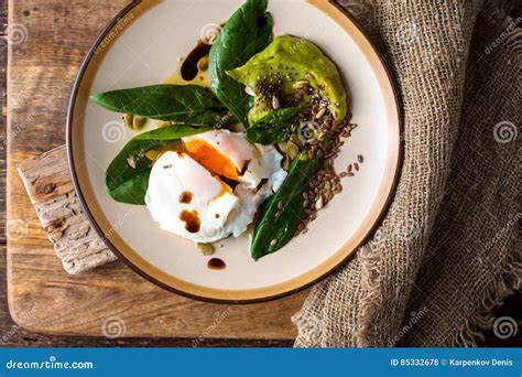 gestroopt ei met avocadoroom en spinazie op de houten hoogste mening als achtergrond stock foto