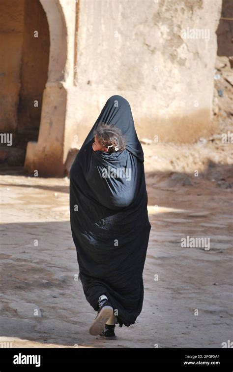 woman wearing  chador walking  daughter  shoulders morocco