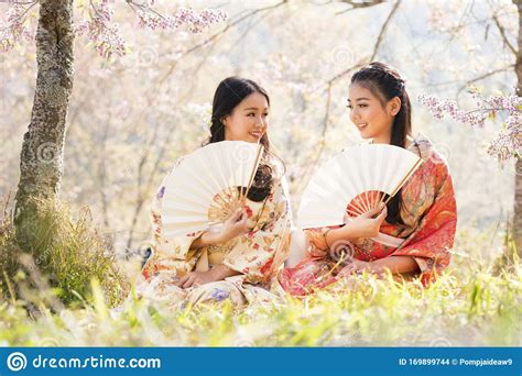 Two Japanese Girl Wearing A Kimono Holding A White Blow