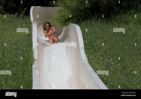 Girl In Bikini Having Fun When Falling Down Water Slide In Water Park