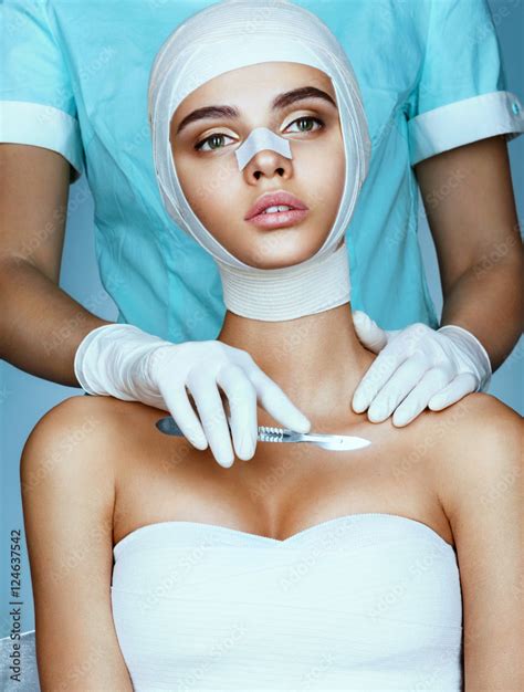 beautiful woman wrapped in medical bandages and plastic surgeon holding