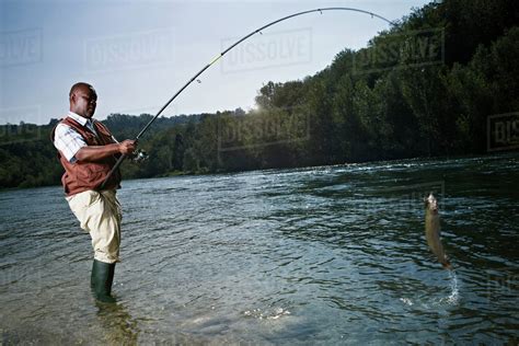 black man catching fish  stream stock photo dissolve