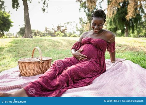 african woman caressing  pregnant belly    picnic  park stock photo image