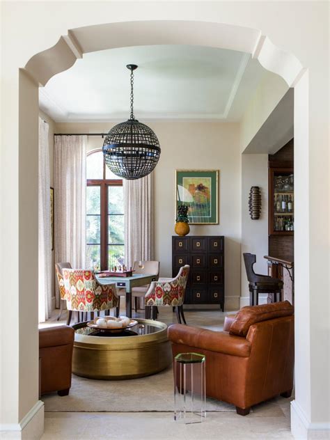 eclectic sitting room  globe chandelier  brown leather armchairs