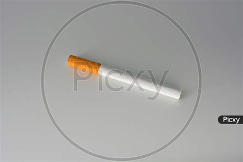 image of one white cigarette with brown filter located on a white