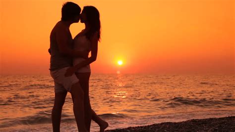 romantic teen couple kissing on the beach at sunset stock footage video