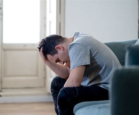 depressed man sitting  sofa   head   hands therapy  depression symptoms