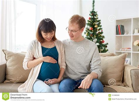pregnant wife with husband at home at christmas stock