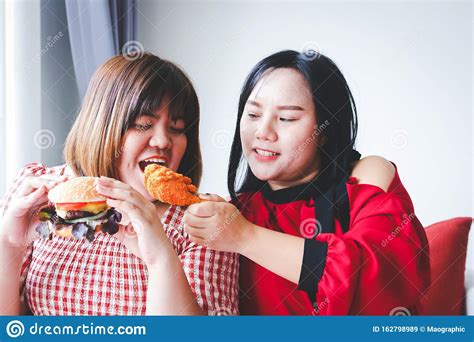 Two Fat Women Are Eating Fried Chicken And Hamburgers