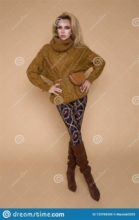 mooi vrouwelijk model  een de herfst winter kleding op een beige achtergrond  de studio