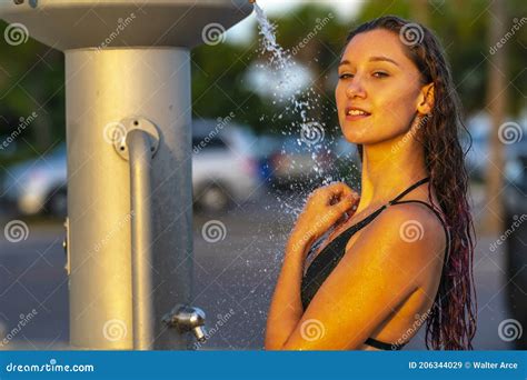 A Lovely Brunette Model Showers Outdoors After Swimming In The Ocean