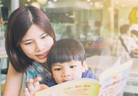 Asian Mother Is Reading Her Son An Educational Book Stock Image