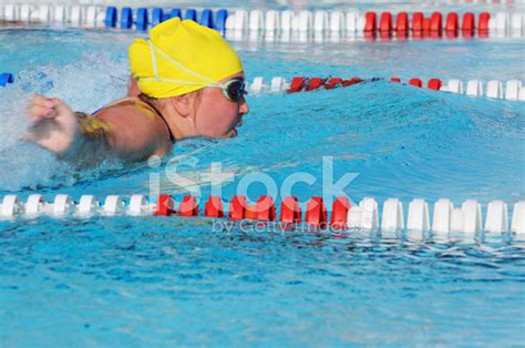 young girl butterfly stroke swimmer racing  pool stock photo