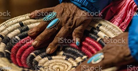 an elderly native american woman wearing turquoise rings on her fingers