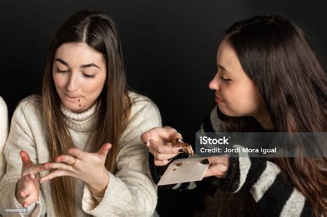 girls lick their fingers while eating chocolate cream desserts stock