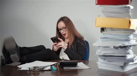 Lazy Female Office Worker Playing On Smartphone In The