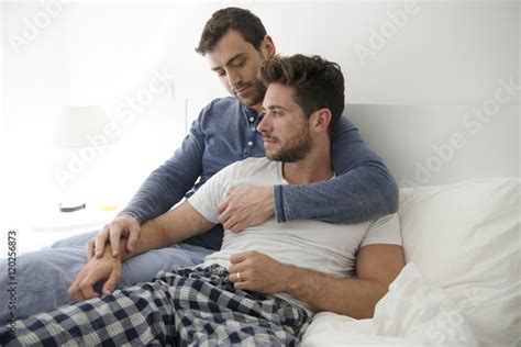 gay male couple at home relaxing in bed together foto stock adobe stock