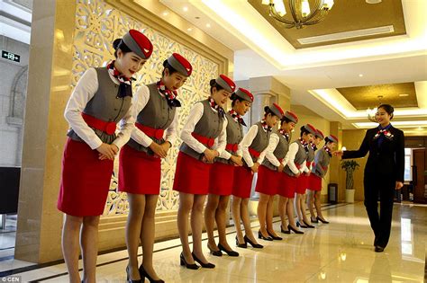 chinese flight attendants practise graceful grin with a chopstick