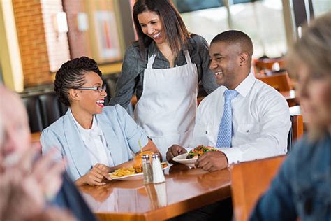 Royalty Free Friendly African American Waitress In Restaurant Serving