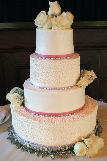 4 tier white buttercream wedding cake with cornelli lace