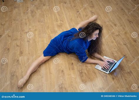 Flexible Woman Exercising At Home In Front Of Her Laptop Stretching