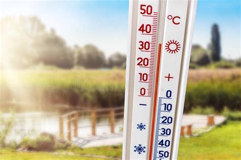 de thermometer  de zomerwarmte toont een hitte van  graden thermometer op nature background