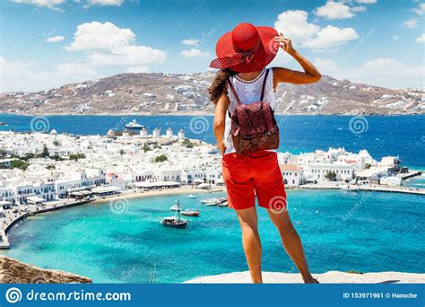 woman stands on a hill over the beautiful town of mykonos