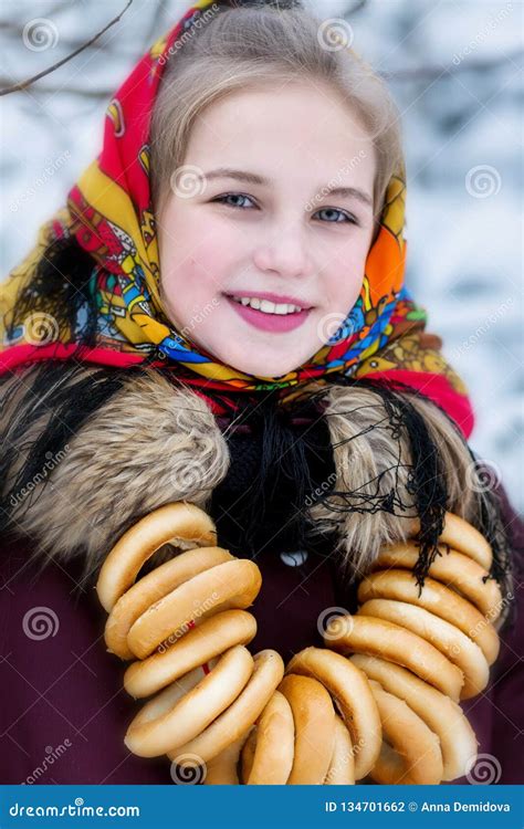 A Young Girl In A Russian Scarf And With A Bunch Of Sheep In The Winter