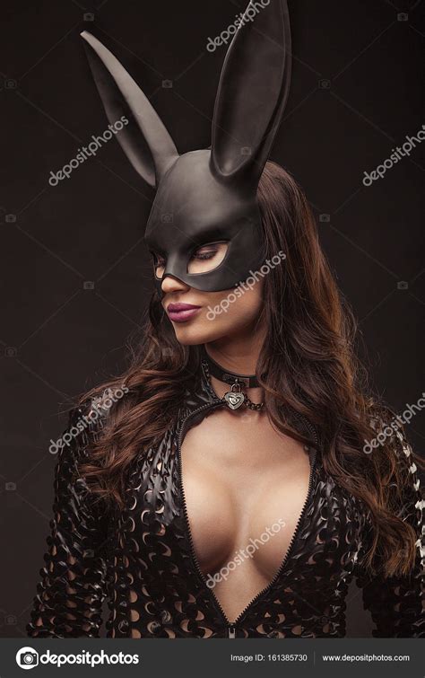 Сексуальная женщина с большой грудью в черной маске