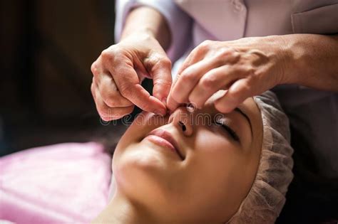 calm girl having spa facial massage in luxurious beauty salon stock