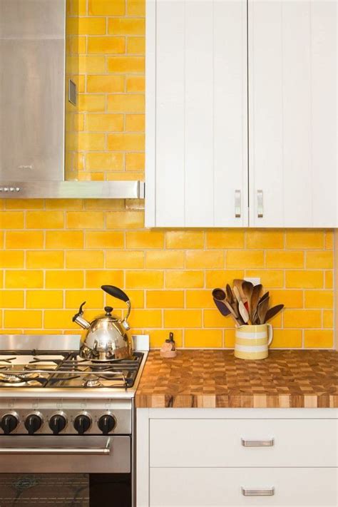 bright  bold yellow subway tile backsplash stainless steel appliances white