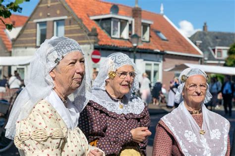 nederlanders met traditioneel kleding en hoofddeksel bij lokale markt redactionele stock