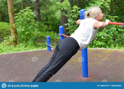 Woman Doing Physical Exercise In A Public Park In Summer Outdoor Stock