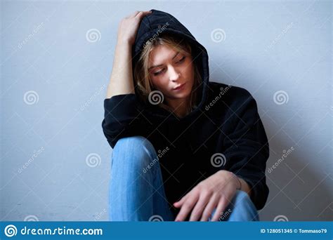 young girl hiding  face  hooded sweatshirt   stock image image  displeased