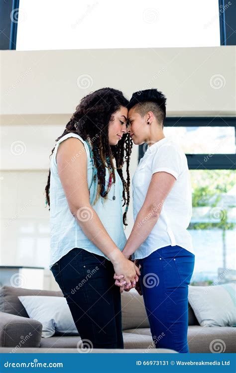 Romantic Lesbian Couple Standing Face To Face And Holding Hands Stock