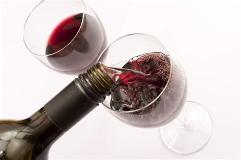 free image of red wine served from a bottle into two glasses