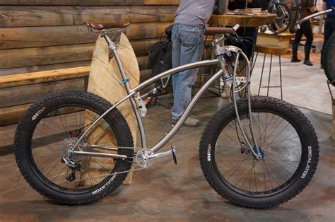silver bicycle sitting  top   wooden floor    log cabin wall