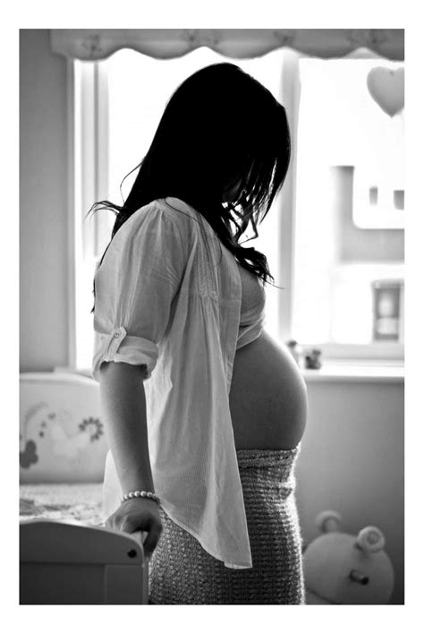 Download A Pregnant Woman Is Standing In Front Of A Window