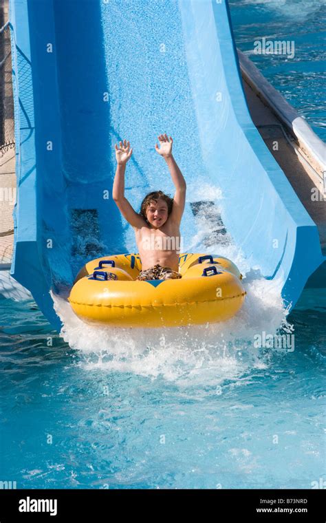 boy sliding  waterslide  innertube  water park stock photo alamy