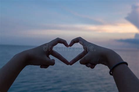 heart   fingers  sunset background stock image image