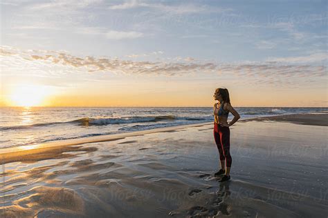 Fit Female Athlete Standing On Beach At Sunrise By Stocksy