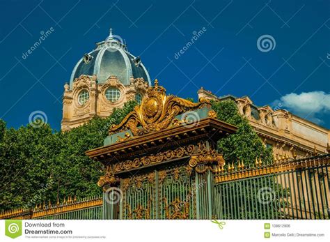 golden iron gate lavishly decorated  dome  sunny blue sky  paris editorial photo