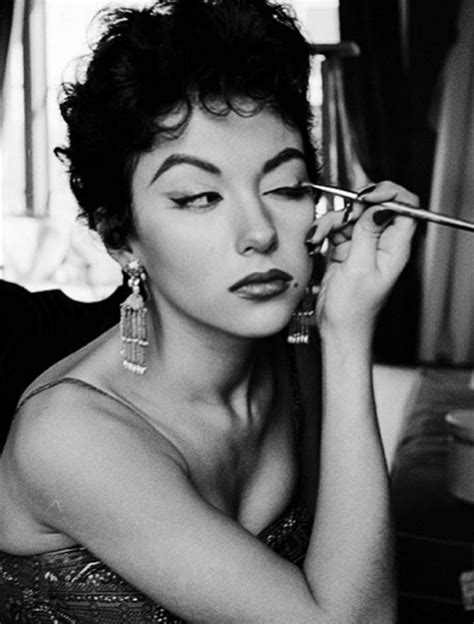 A Black And White Photo Of A Woman Getting Her Make Up Done