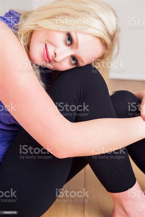 Beautiful Teenage Fashion Model Sitting On Floor With Hugging Knees
