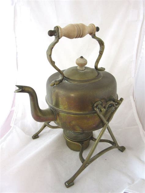 antique vintage brass kettle on a stand with a heating